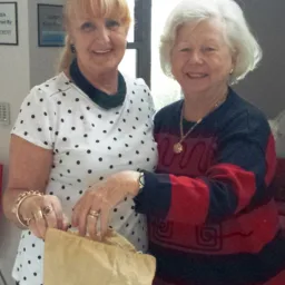 Volunteer Carmen Cook (L) drawing the winning raffle ticket with the assistance of our guests, Philippa.